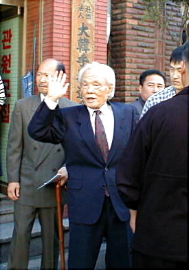 Kwan Jang Nim waves at crowd at central dojang